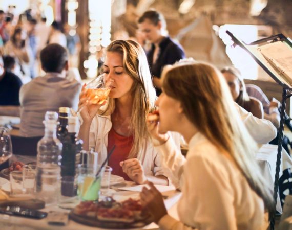 Damer der drikker vin på restaurant