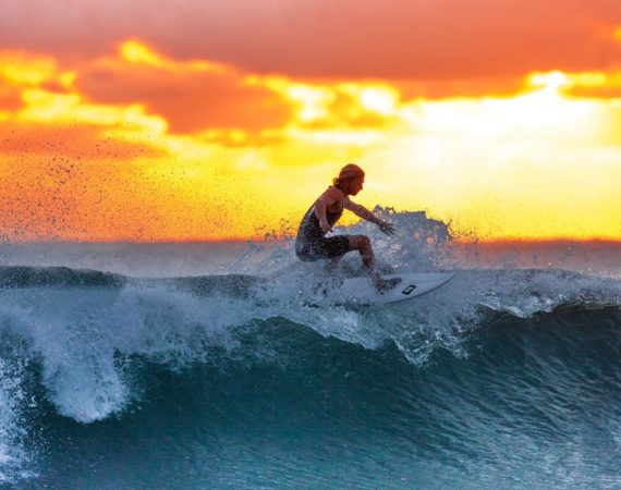 Mand surfer i solnedgang på hawaii